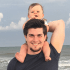 Bronley with his son on his shoulders at the beach